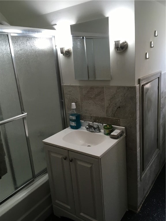 bathroom with backsplash, enclosed tub / shower combo, and vanity with extensive cabinet space