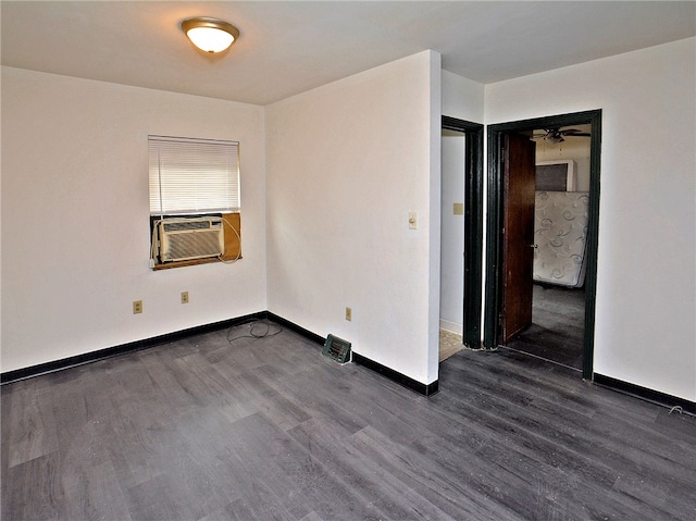 spare room featuring ceiling fan and dark wood-type flooring