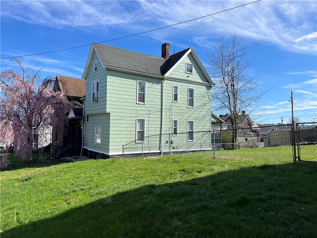 rear view of property with a lawn