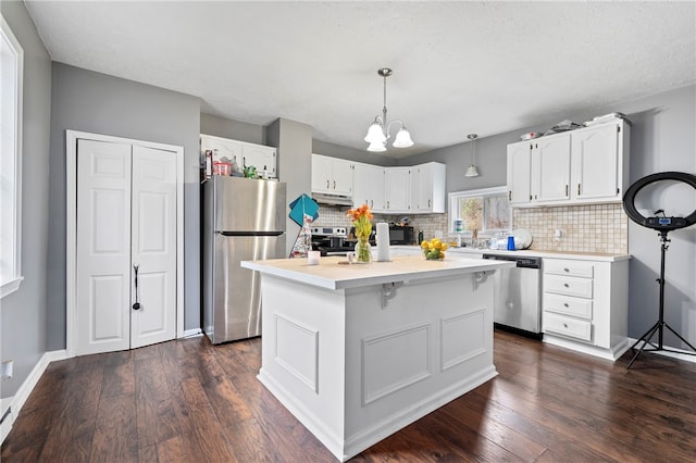 kitchen featuring white cabinets, dark hardwood / wood-style floors, tasteful backsplash, and stainless steel appliances