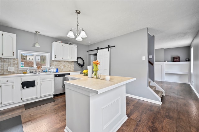 kitchen with dishwasher, white cabinets, and a barn door