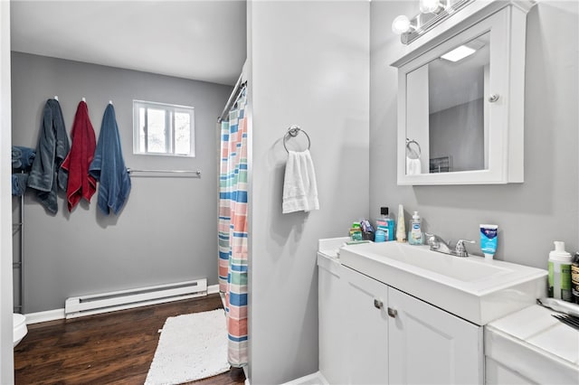 bathroom featuring a baseboard heating unit, hardwood / wood-style flooring, and vanity