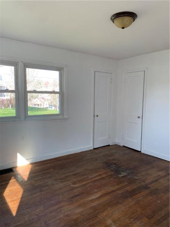 spare room with dark wood-type flooring