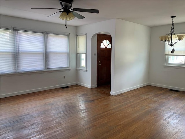 entrance foyer with ceiling fan with notable chandelier and dark hardwood / wood-style flooring