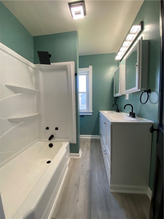 bathroom with a tub, hardwood / wood-style floors, and vanity