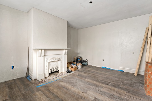 unfurnished living room featuring a fireplace and dark hardwood / wood-style floors