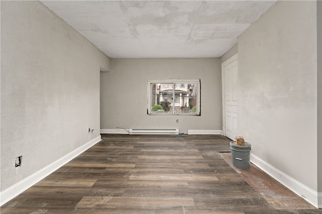 spare room featuring dark hardwood / wood-style flooring and a baseboard heating unit