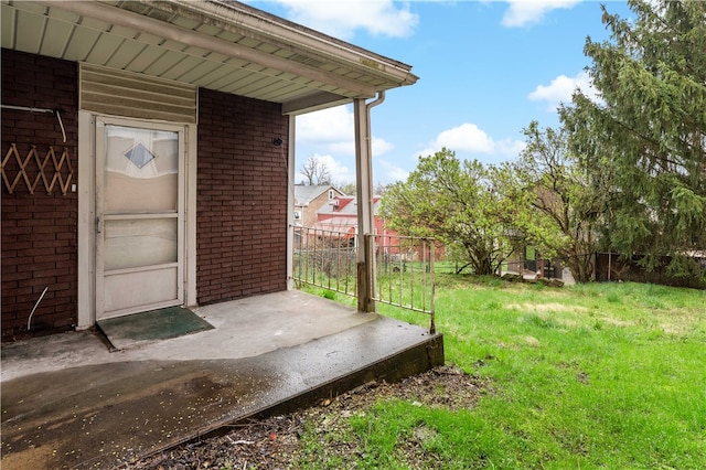 view of exterior entry featuring a lawn