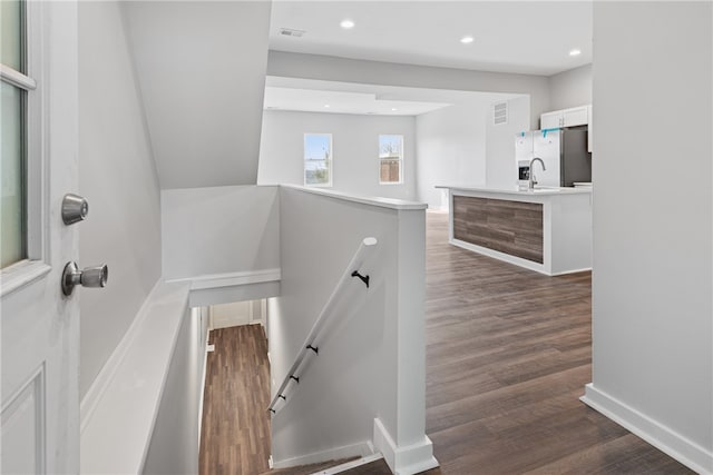 staircase featuring dark hardwood / wood-style flooring and sink