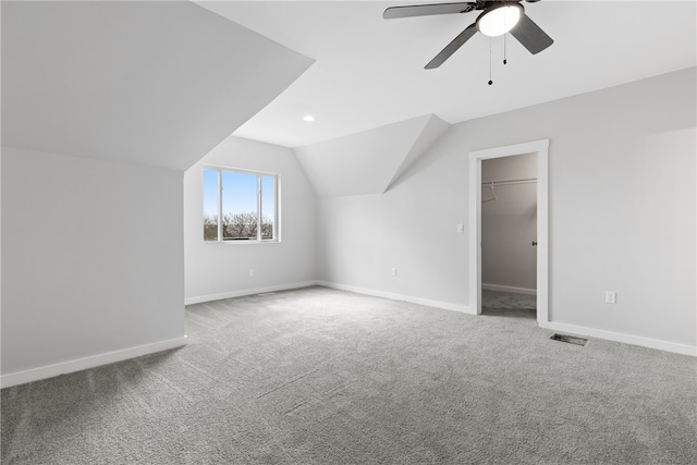 bonus room featuring ceiling fan, light carpet, and vaulted ceiling