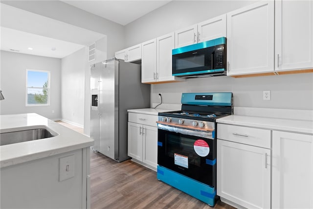 kitchen featuring white cabinets, dark hardwood / wood-style floors, stainless steel appliances, and sink