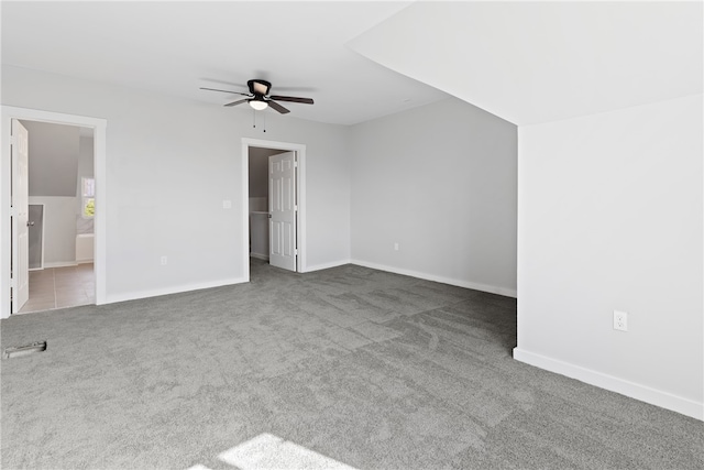 unfurnished room featuring ceiling fan and dark carpet