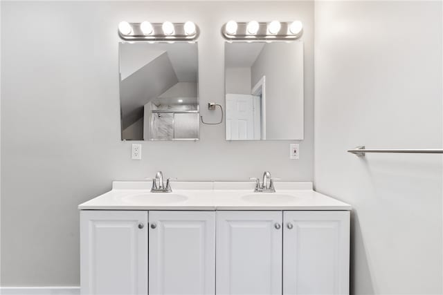 bathroom with dual vanity and vaulted ceiling