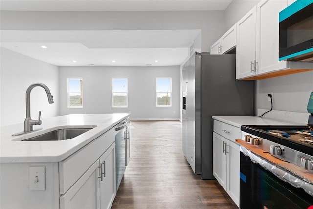 kitchen featuring range, dark wood-type flooring, white cabinetry, dishwasher, and sink