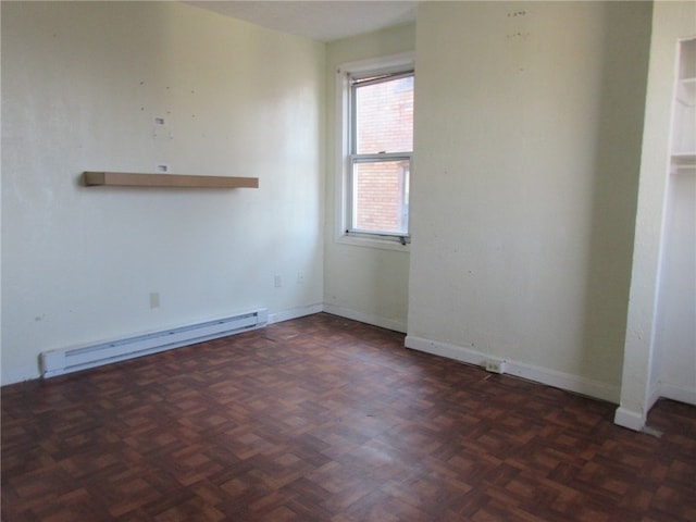 empty room with dark parquet floors and a baseboard heating unit