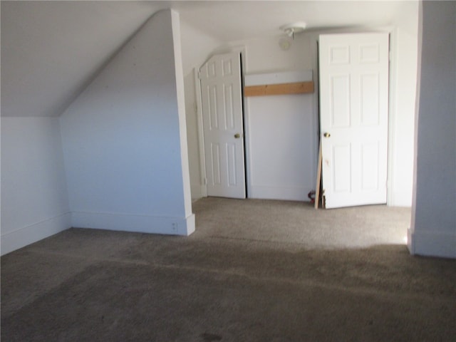 bonus room featuring lofted ceiling and dark colored carpet