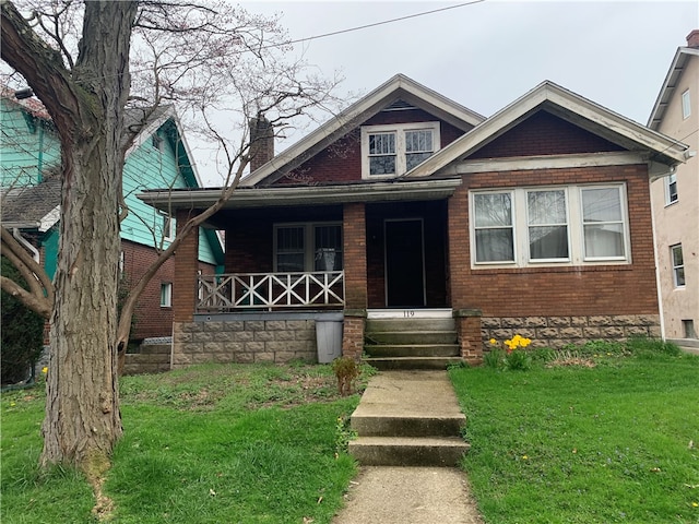 view of front of property featuring covered porch and a front yard