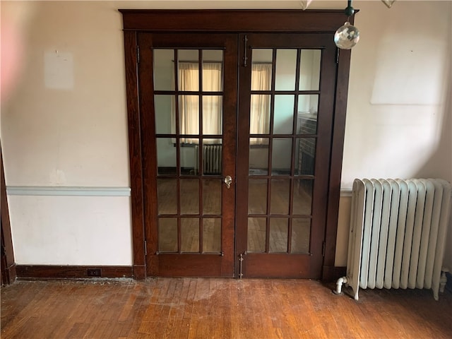 interior space with french doors and radiator heating unit