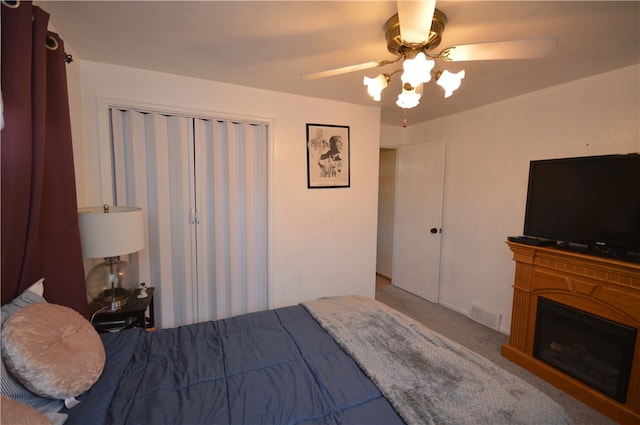 carpeted bedroom with a closet and ceiling fan