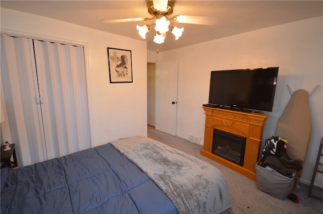 bedroom with carpet floors, ceiling fan, and a closet