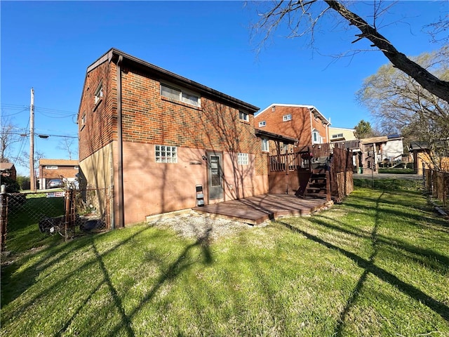 back of property with a deck and a lawn