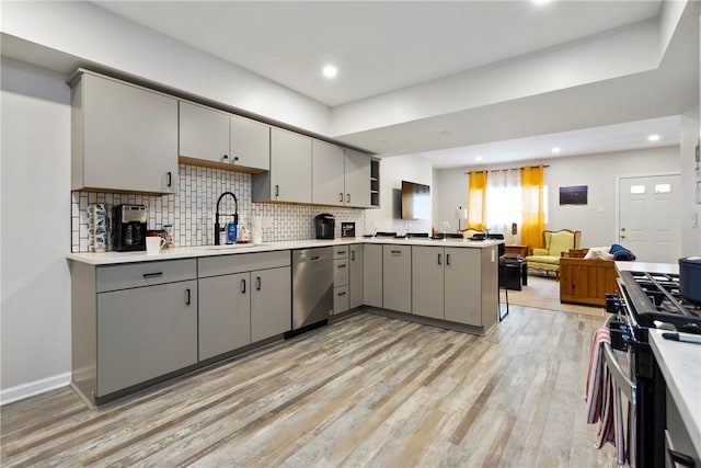 kitchen with gray cabinetry, light hardwood / wood-style flooring, appliances with stainless steel finishes, sink, and tasteful backsplash