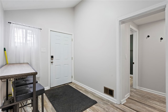 entryway featuring vaulted ceiling and light wood-type flooring