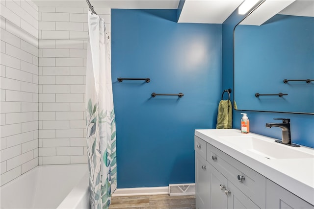 bathroom featuring hardwood / wood-style flooring, shower / bathtub combination with curtain, and vanity