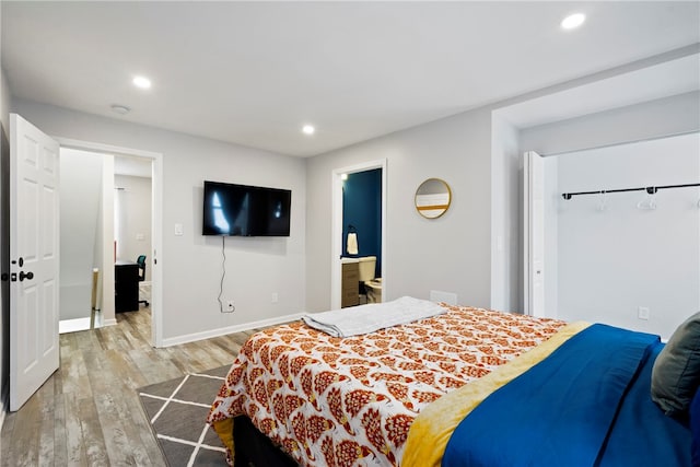 bedroom featuring light hardwood / wood-style floors and ensuite bath