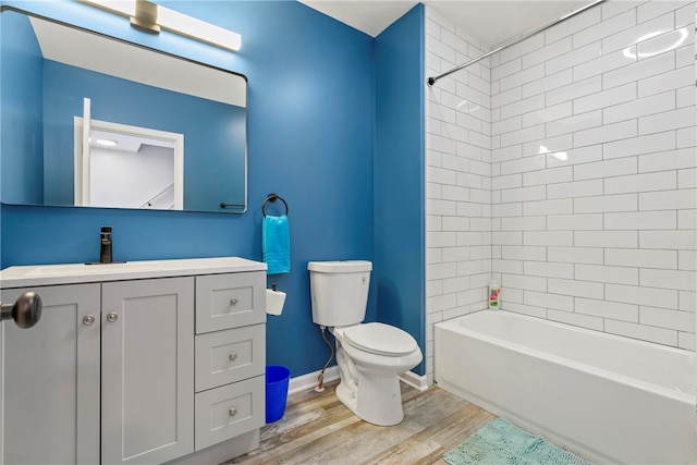 full bathroom featuring vanity, hardwood / wood-style flooring, toilet, and tiled shower / bath combo