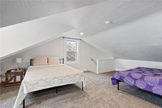 carpeted bedroom featuring vaulted ceiling and a textured ceiling