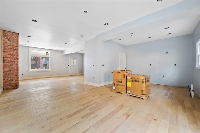 interior space with brick wall and light hardwood / wood-style floors