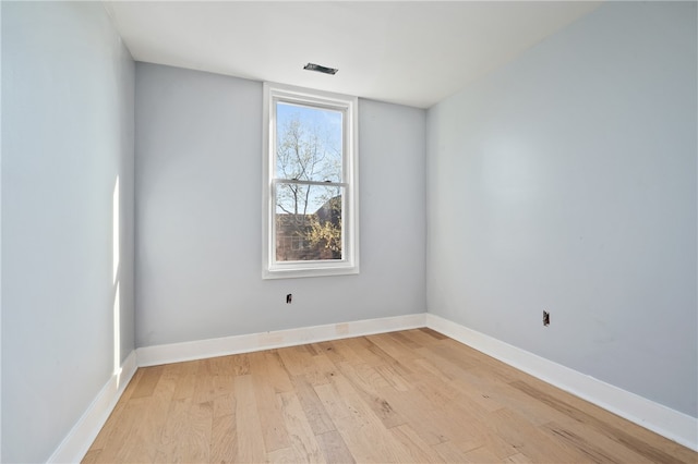 spare room featuring a healthy amount of sunlight and light hardwood / wood-style flooring