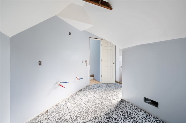 interior space with vaulted ceiling and light tile floors