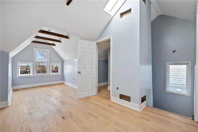 bonus room with light hardwood / wood-style floors and lofted ceiling with skylight