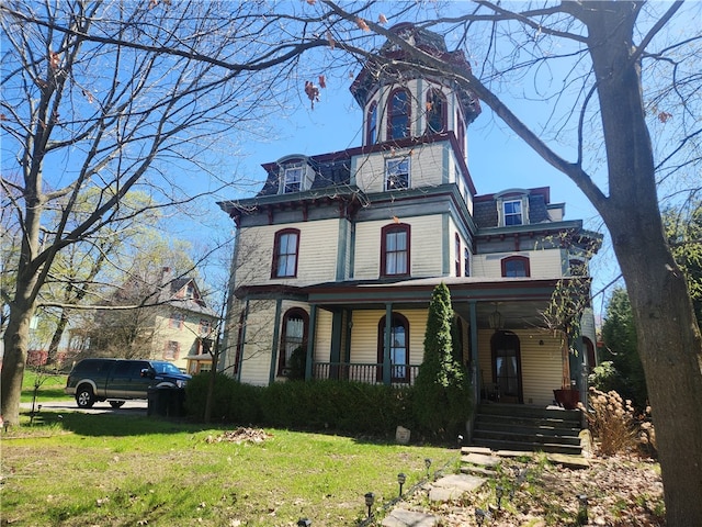 view of front of house featuring covered porch and a front yard