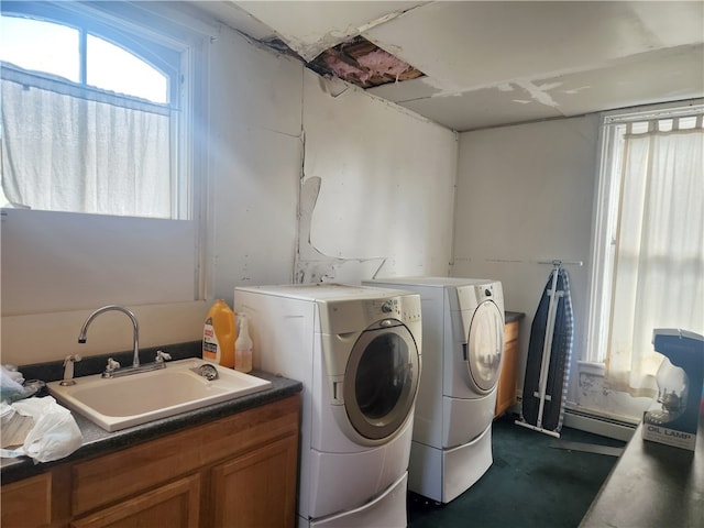 laundry room with a baseboard heating unit, sink, and washer and dryer