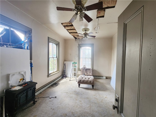 living area featuring ceiling fan, carpet flooring, and baseboard heating