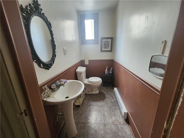 bathroom featuring sink, toilet, tile floors, and baseboard heating