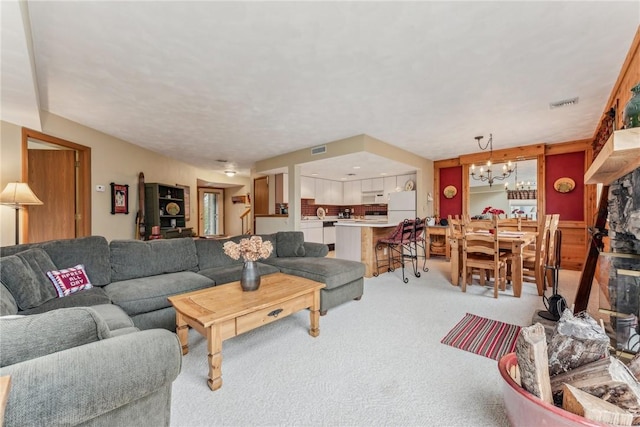 carpeted living room featuring a chandelier