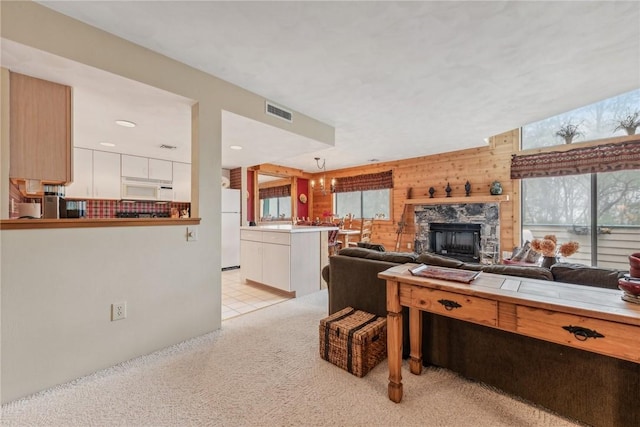 carpeted living room with wooden walls and a fireplace