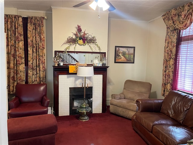 living room with ornamental molding, carpet flooring, a brick fireplace, and ceiling fan