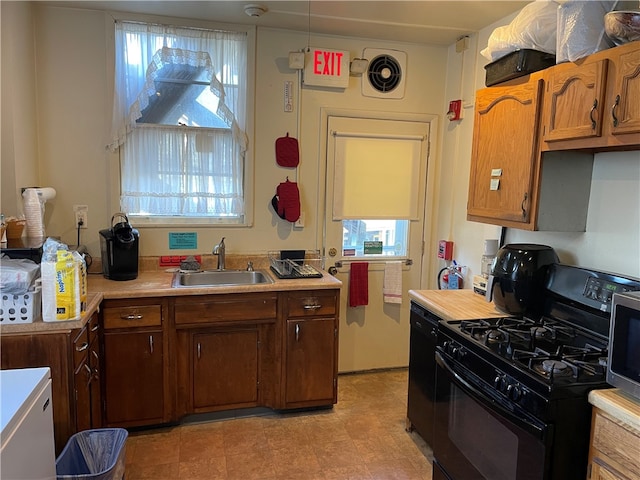 kitchen featuring hanging light fixtures, light tile floors, sink, range with gas cooktop, and dishwasher