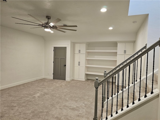 stairway featuring a skylight, ceiling fan, and carpet floors