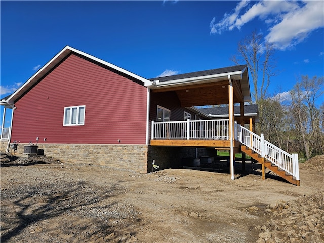 view of side of home with central AC and a deck