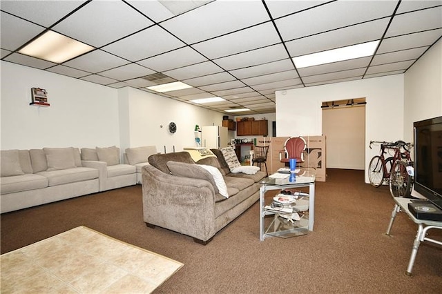 living room featuring dark colored carpet, a barn door, and a paneled ceiling