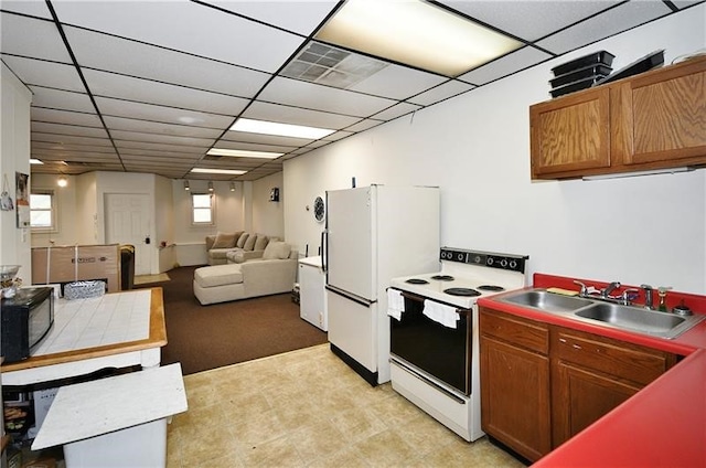 kitchen featuring a drop ceiling, white appliances, sink, and light tile flooring