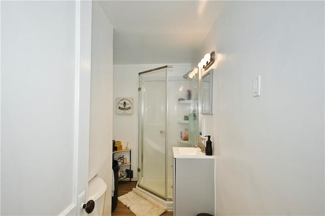 bathroom featuring an enclosed shower, vanity, and hardwood / wood-style floors