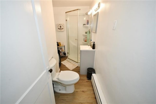 bathroom with a baseboard heating unit, walk in shower, toilet, wood-type flooring, and vanity