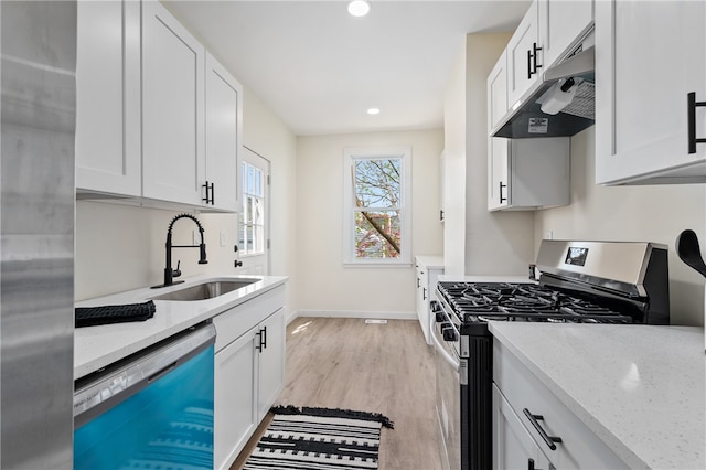 kitchen featuring sink, light wood-type flooring, stainless steel appliances, and white cabinetry